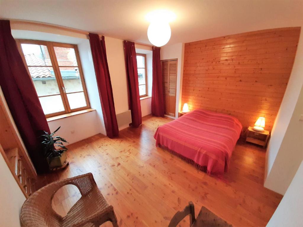 ein Schlafzimmer mit einem Bett mit einer Holzwand in der Unterkunft Le Clos de l'Atre in La Chaise-Dieu