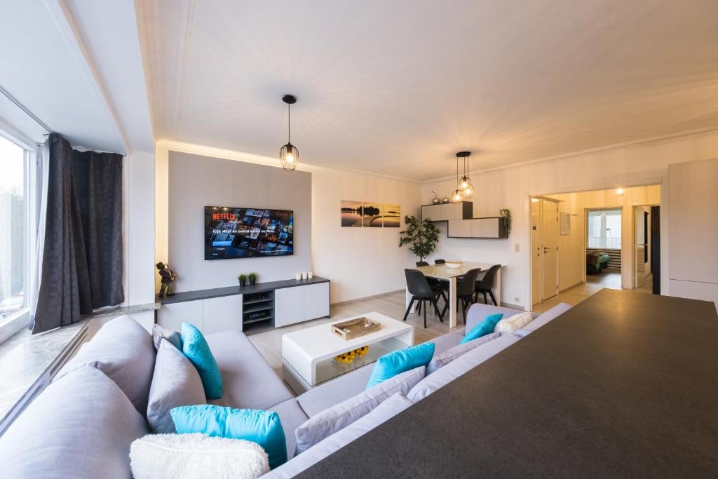 een woonkamer met een bank en een tafel bij Ostend Center Parkview Apartment Free Parking in Oostende