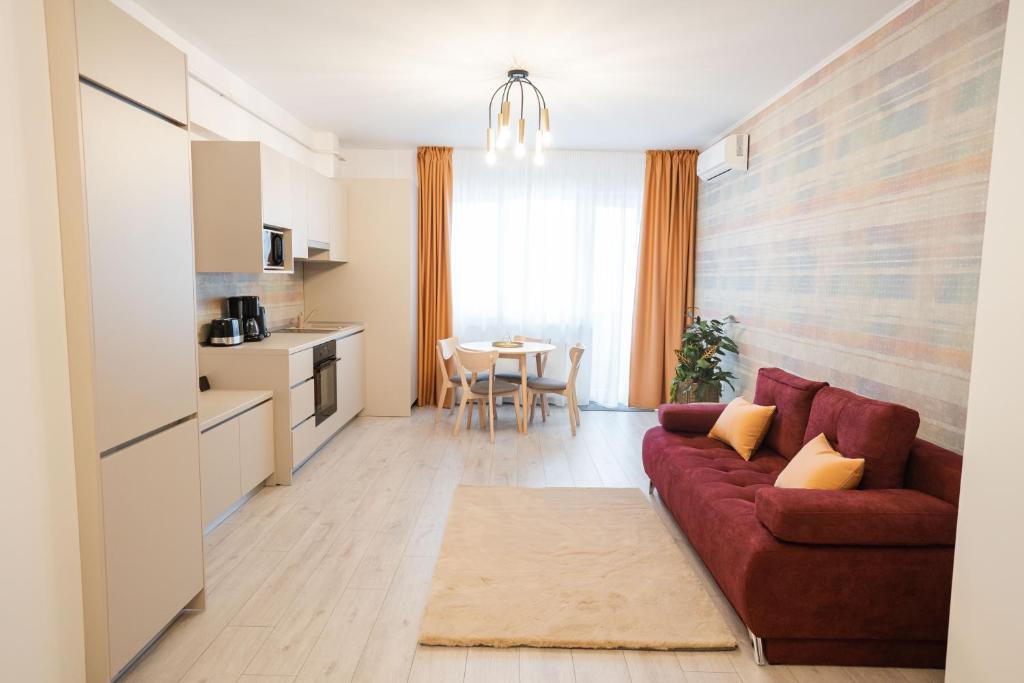 sala de estar con sofá rojo y cocina en Central Tower Apartments en Suceava