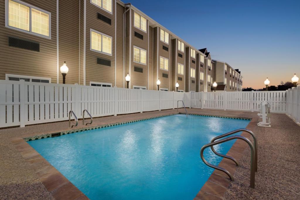 a swimming pool in front of a building at Super 8 by Wyndham San Antonio Airport North in San Antonio