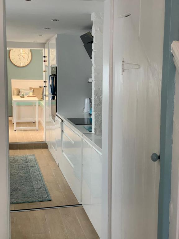 eine Küche mit weißen Schränken und einer Arbeitsplatte in der Unterkunft Blue Haven in Brighton & Hove