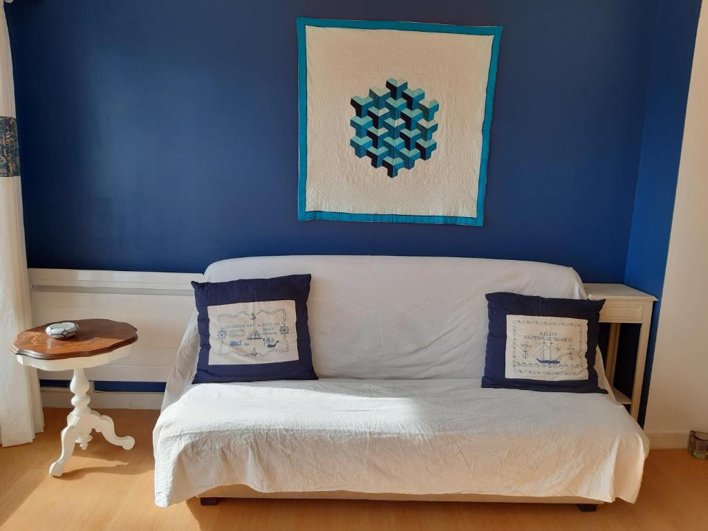 uma sala de estar com um sofá e uma parede azul em Près de la mer em Le Pouliguen