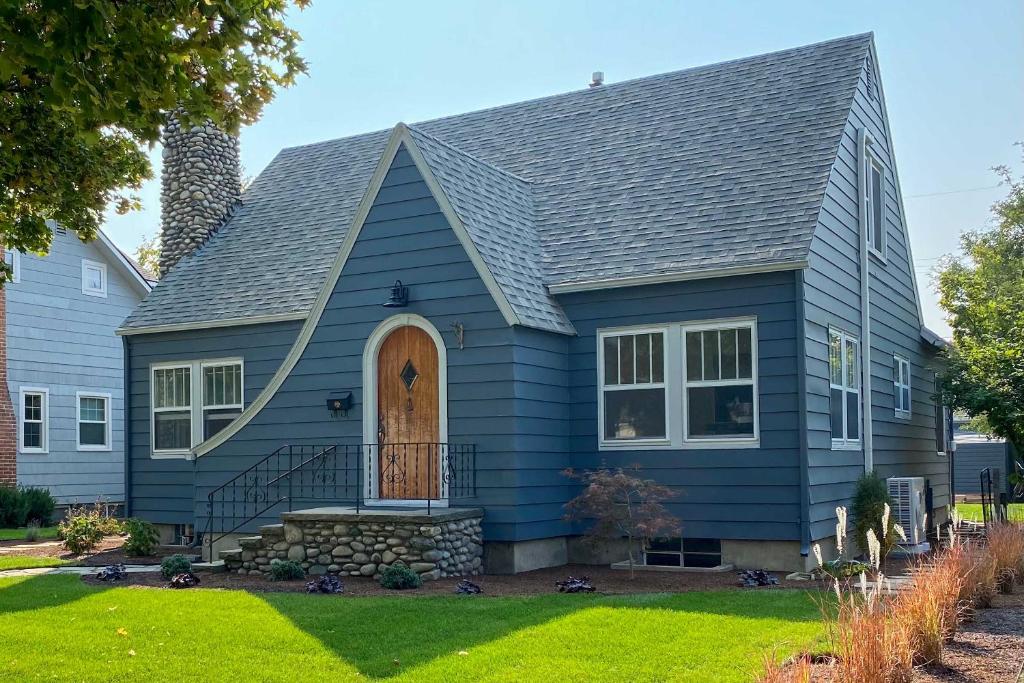 a blue house with a gambrel roof at Boise Tudor Home with Game Room Less Than 2 Mi to Downtown! in Boise