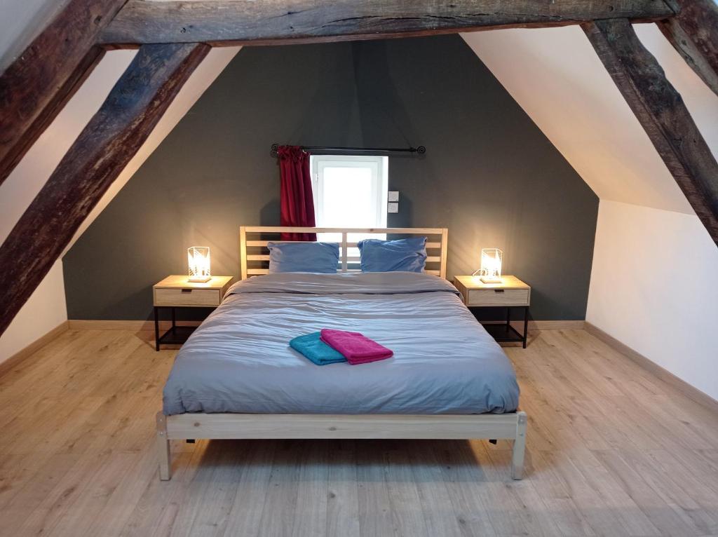 a bedroom with a bed with two lamps on both sides at La graineterie89 in Pont-sur-Yonne
