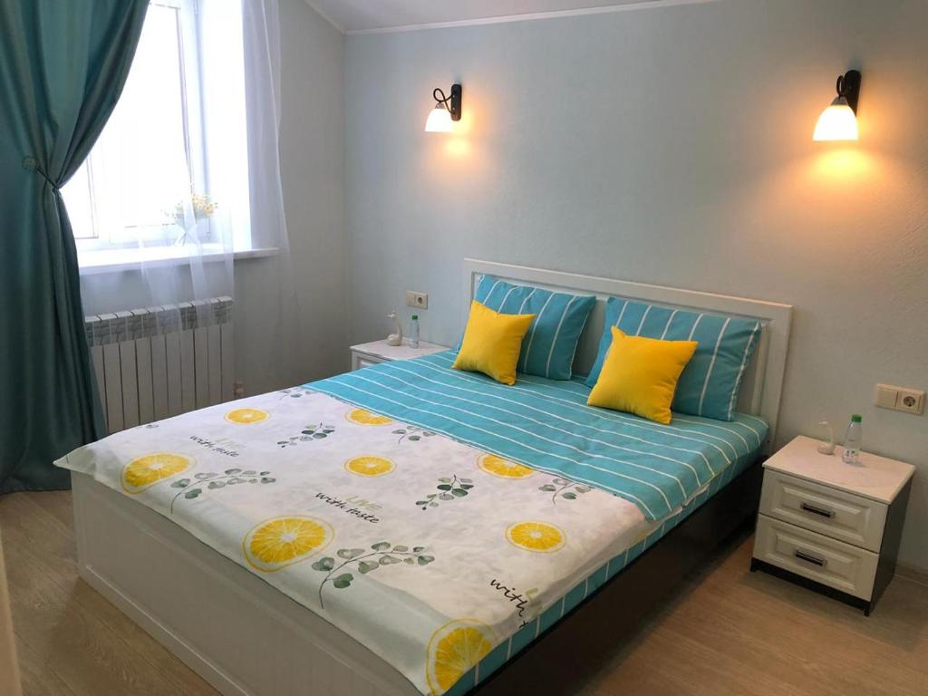コストロマにあるТаунхаус ЛЮКСのベッドルーム1室(青と黄色の枕が備わるベッド1台付)