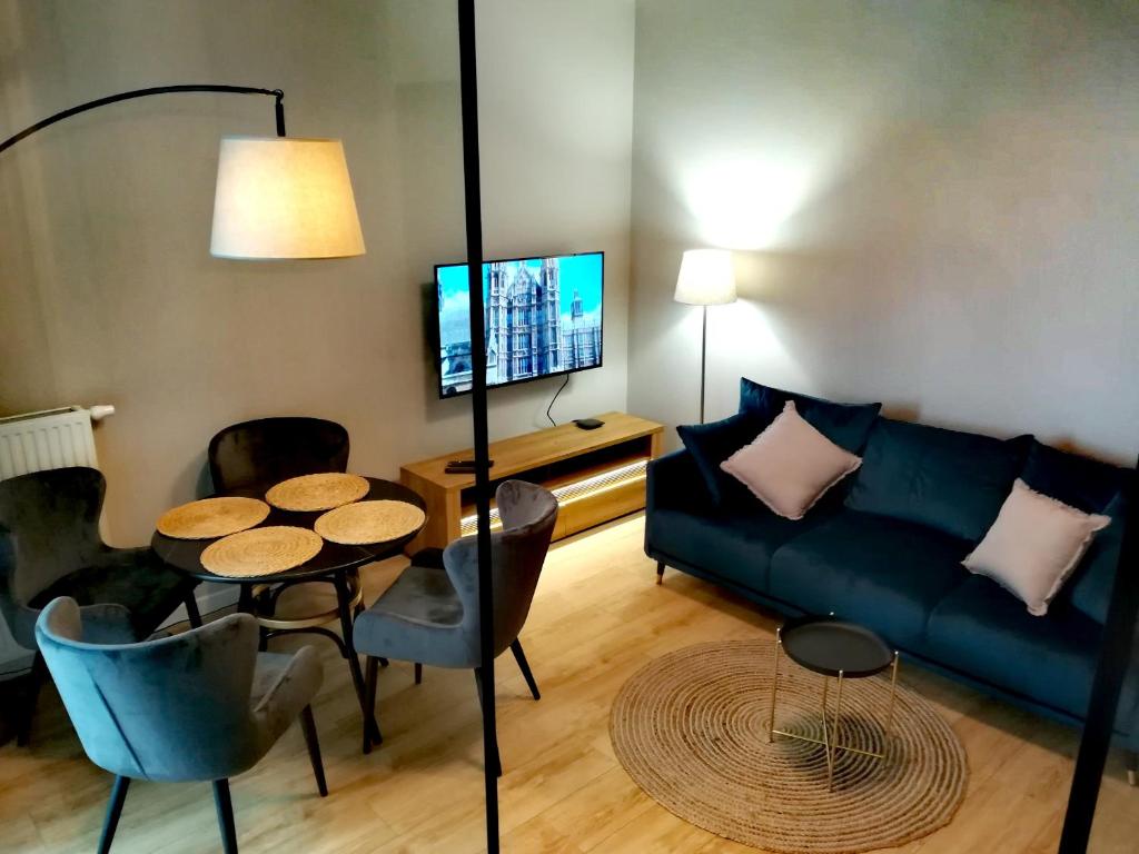 ein Wohnzimmer mit einem Sofa und einem Tisch in der Unterkunft Długie Ogrody Apartment 209 Gdańsk in Danzig