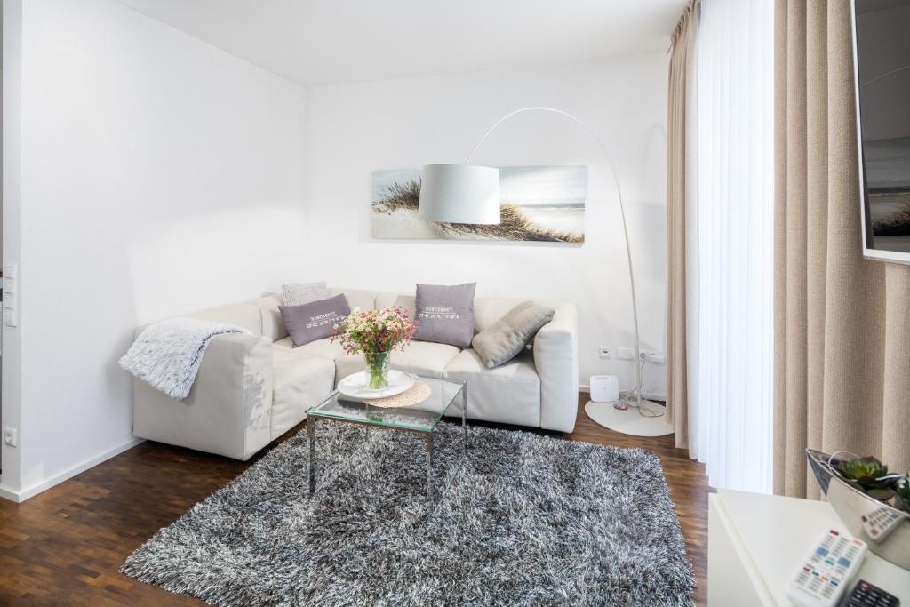 - un salon avec un canapé blanc et une table en verre dans l'établissement NeysTime, à Norderney