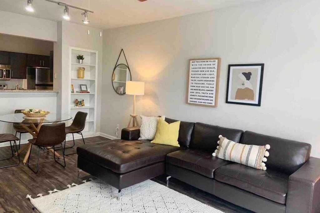 een woonkamer met een leren bank en een tafel bij Newly Furnished 1BR Apartment w/ Hermann Park View in Houston