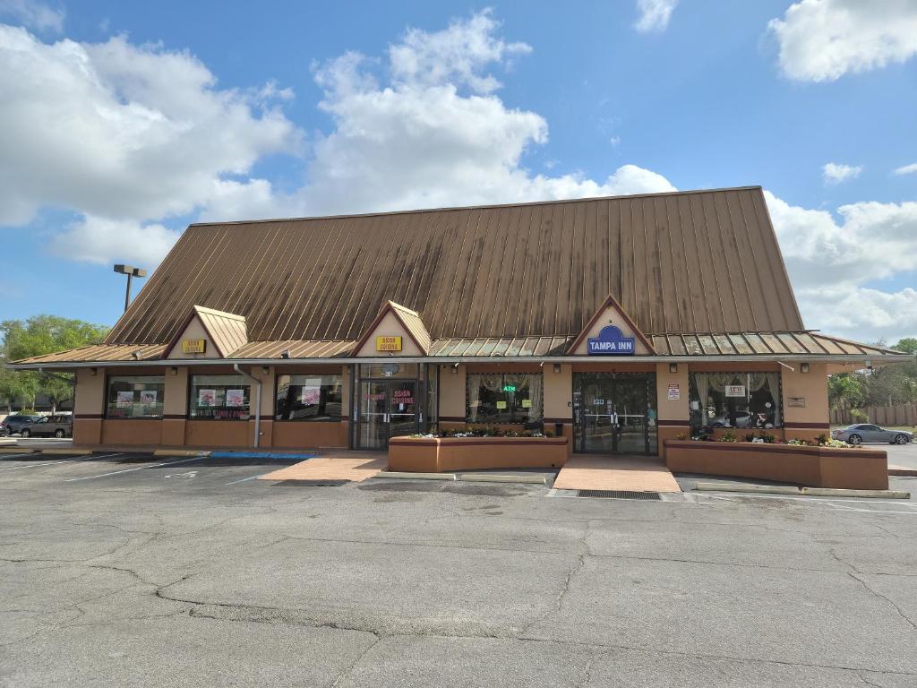 uma loja com um grande edifício com um telhado castanho em Tampa Inn Near Busch Gardens em Tampa