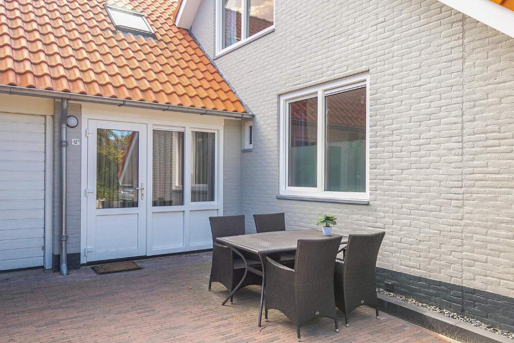 een patio met een tafel en stoelen voor een huis bij KASITA12 in Domburg