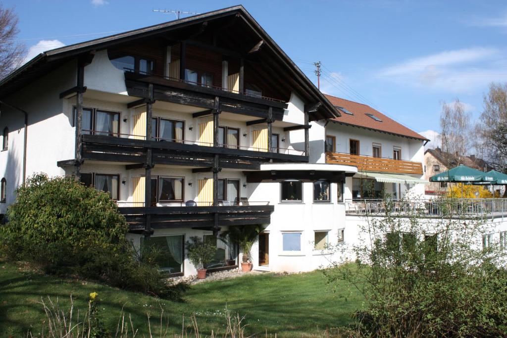 ein großes weißes Gebäude mit schwarzem Dach in der Unterkunft Hotel Panorama in Waldachtal