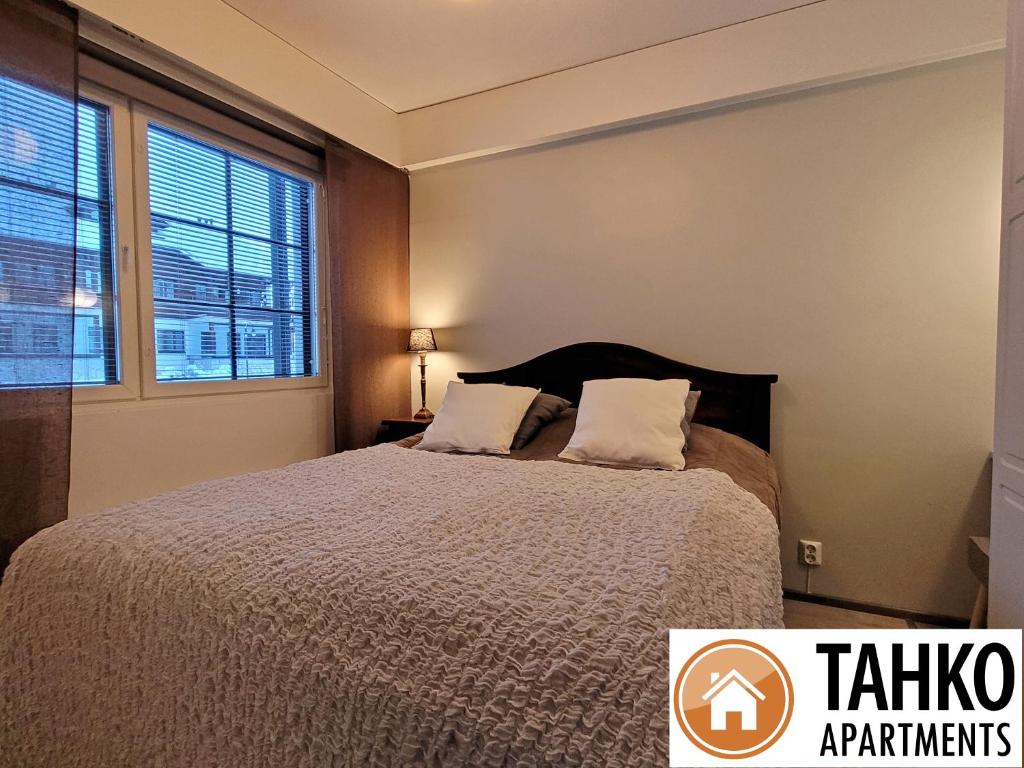 Un dormitorio con una cama y una ventana grande. en Apartments Golf, en Tahkovuori