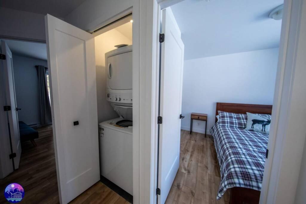 a small bedroom with a bed and a tv at Chalet le Caribou- Chalets Galaxia in Saint-Alphonse-Rodriguez