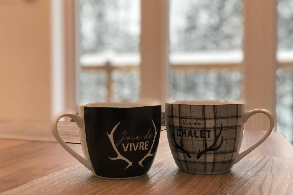 two coffee cups sitting on top of a table at Chalet le Caribou- Chalets Galaxia in Saint-Alphonse-Rodriguez