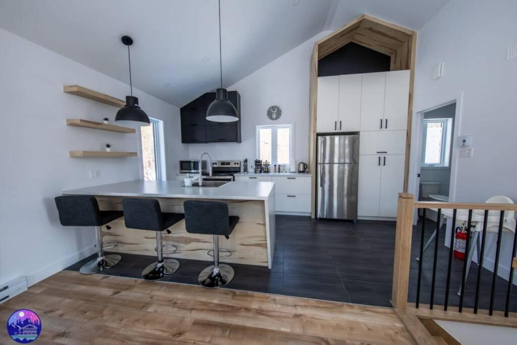 a kitchen with a large island in a room at Chalet le Caribou- Chalets Galaxia in Saint-Alphonse-Rodriguez
