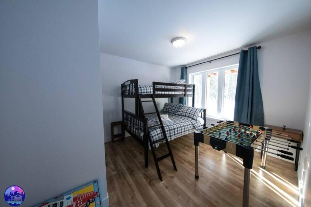 a small room with a bunk bed and a table at Chalet le Caribou- Chalets Galaxia in Saint-Alphonse-Rodriguez