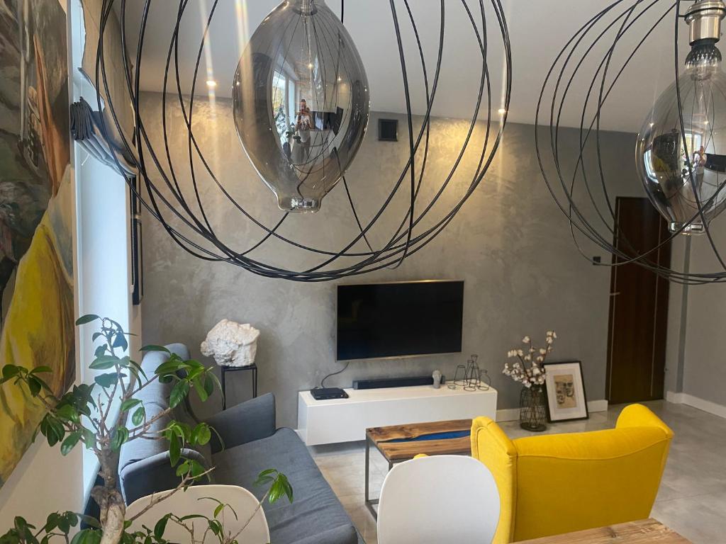 a living room with a couch and a tv at Apartament Centrum- Art&Design in Konin