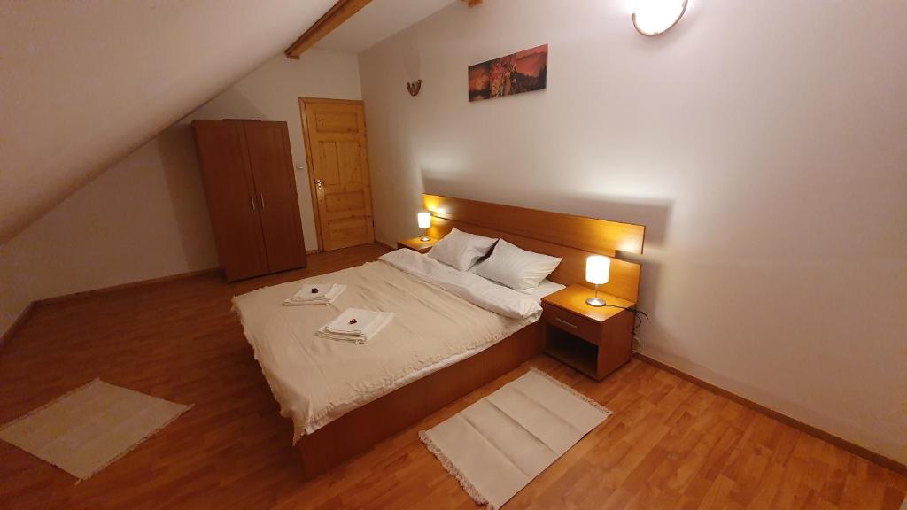 a bedroom with a large bed and two lamps at Vila Panselutelor 6 in Sinaia