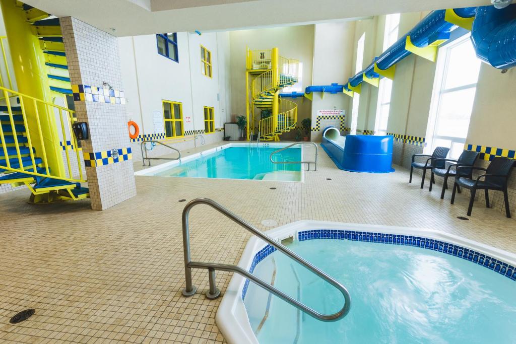 duży kryty basen z wanną z hydromasażem w budynku w obiekcie Redwood Inn & Suites w mieście Clairmont