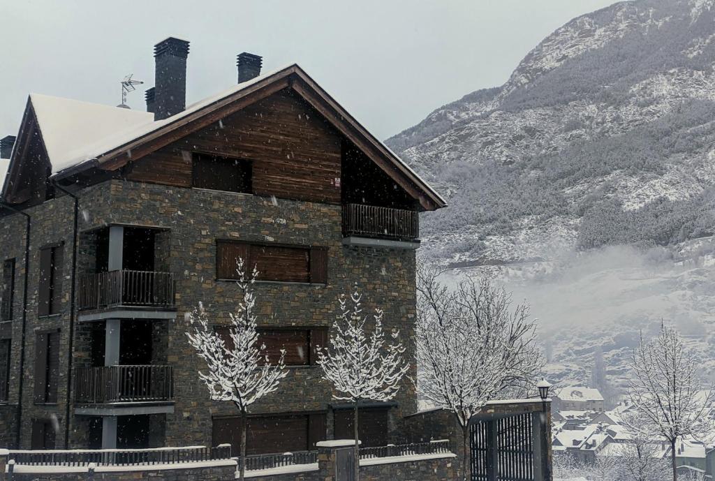 ベナスケにあるPleta del Monの山前に雪が積もった建物