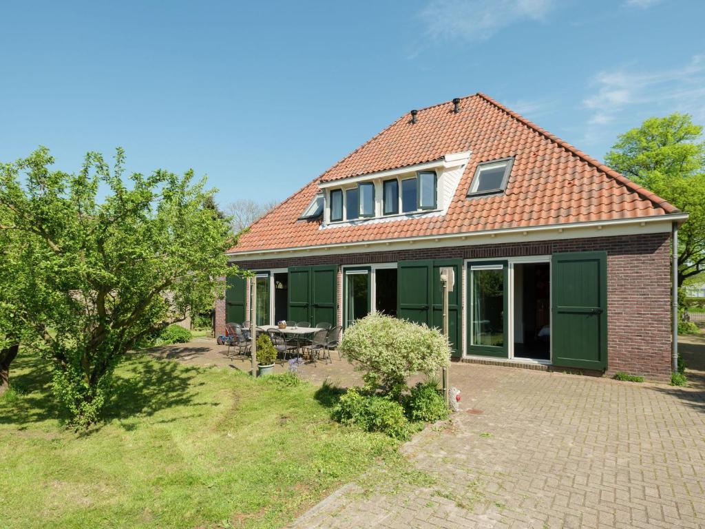 una imagen de una casa con jardín en Spacious farmhouse in wooded area, en Zuidoostbeemster