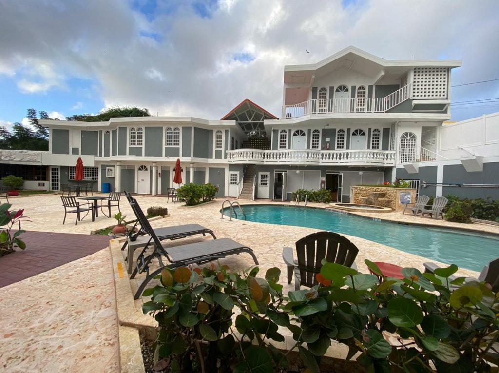 a large house with a swimming pool in front of it at The Village Inn in Carolina