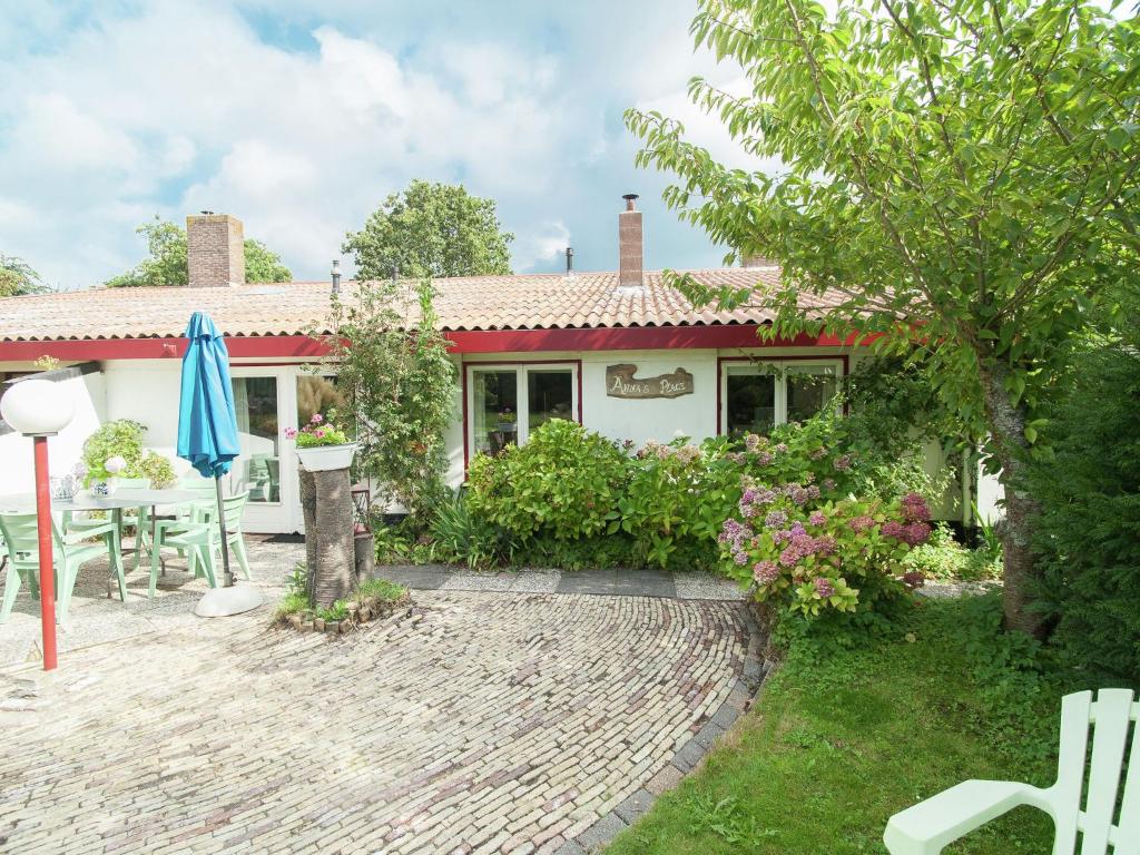 スコールルにあるHoliday home in Schoorl with a gardenのパティオと傘付きの家