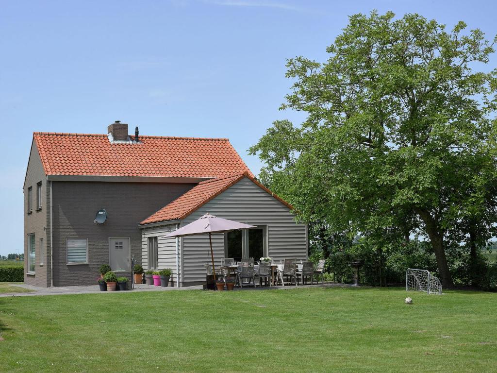 una casa con mesa y sillas en un patio en Holiday home in a rural location near sea, en Zuidzande