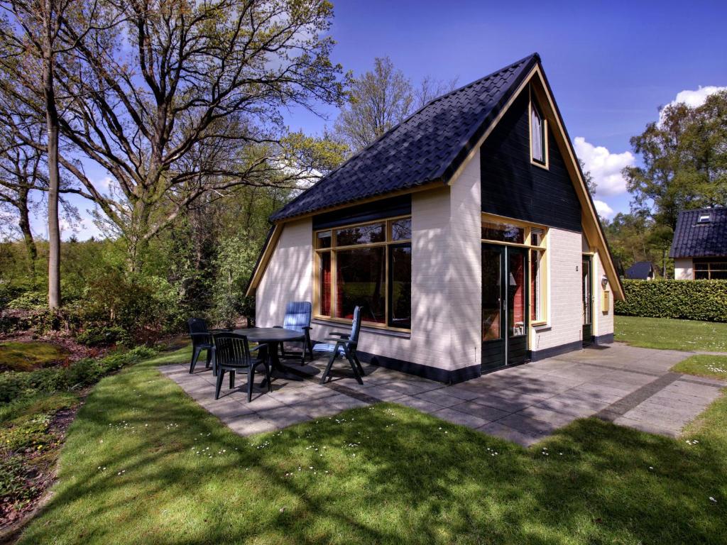 ダルフセンにあるCozy holiday home with a bubble bath, near Zwolleの庭のテーブルと椅子付きの家