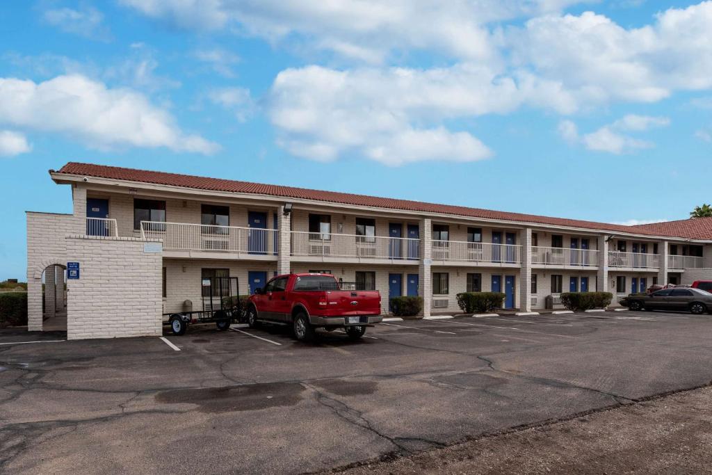 a building with a red truck parked in a parking lot at Motel 6-Eloy, AZ - Casa Grande in Eloy