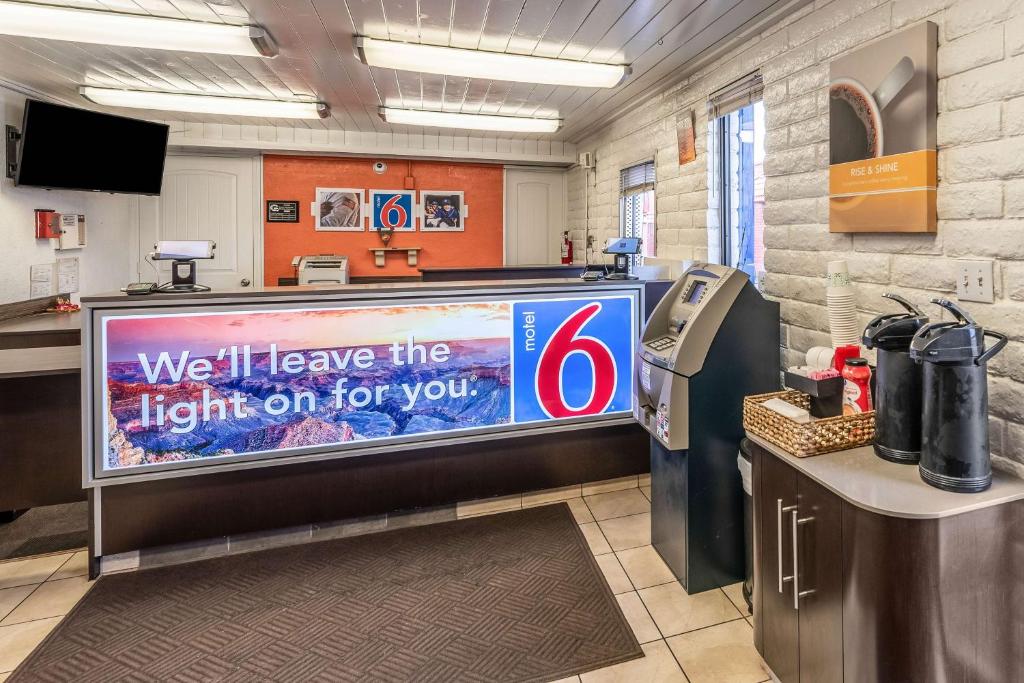 a large tv in a waiting room with a sign on it at Motel 6-Eloy, AZ - Casa Grande in Eloy