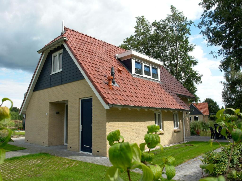 dom z psem siedzącym na dachu w obiekcie Spacious holiday home with a dishwasher, 20km from Assen w mieście Westerbork