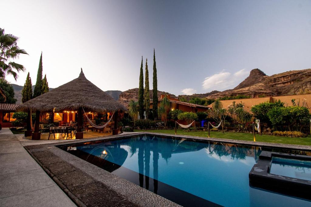 - une piscine dans un complexe avec des montagnes en arrière-plan dans l'établissement Quinta Ascensión Hotel Boutique Only Adults, à Malinalco