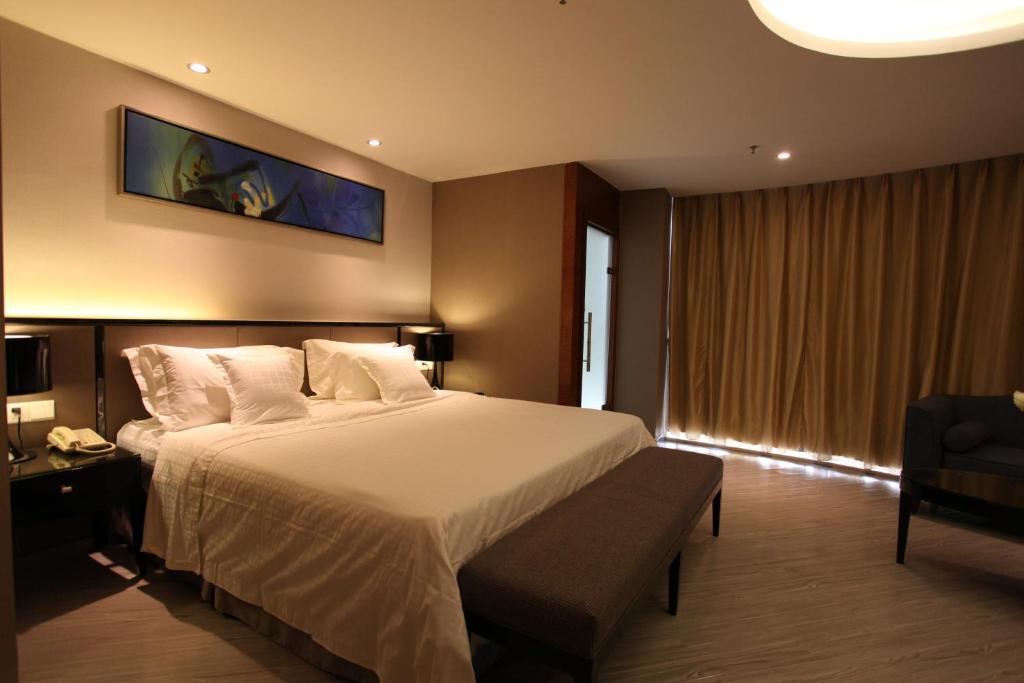 Pokój hotelowy z łóżkiem i krzesłem w obiekcie Ramada Meizhou w Meizhou