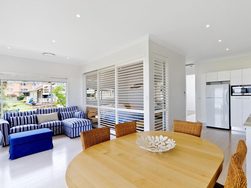 een keuken en een woonkamer met een houten tafel en stoelen bij Comfy Beachfront Unit, Unbeatable Location & Views in Avoca Beach
