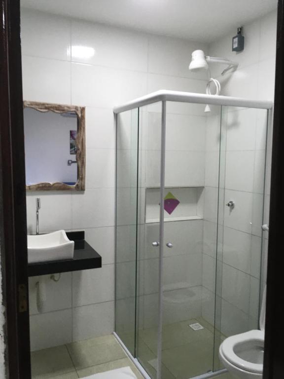 a glass shower in a bathroom with a sink at Pousada Brisa e Mar in Praia do Frances
