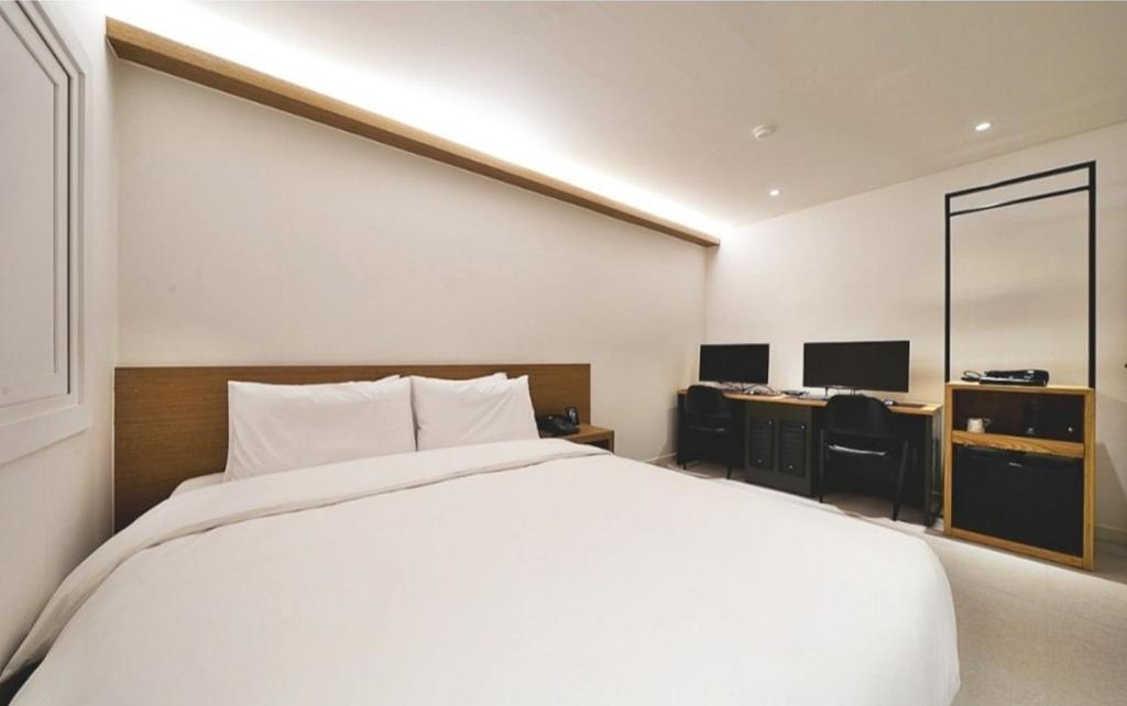 Postel nebo postele na pokoji v ubytování Busan Seomyeon Business Hotel J7