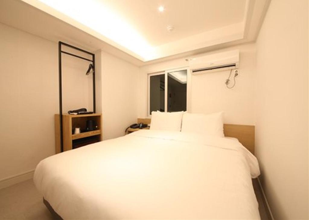 Postel nebo postele na pokoji v ubytování Busan Seomyeon Business Hotel J7