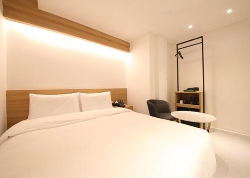 Postel nebo postele na pokoji v ubytování Busan Seomyeon Business Hotel J7