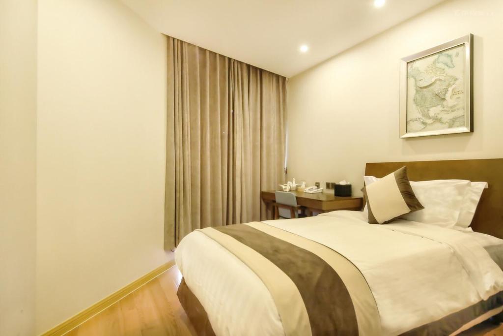 a bedroom with a large bed and a table at Green Court Residence Jinqiao Diamond Shanghai in Shanghai