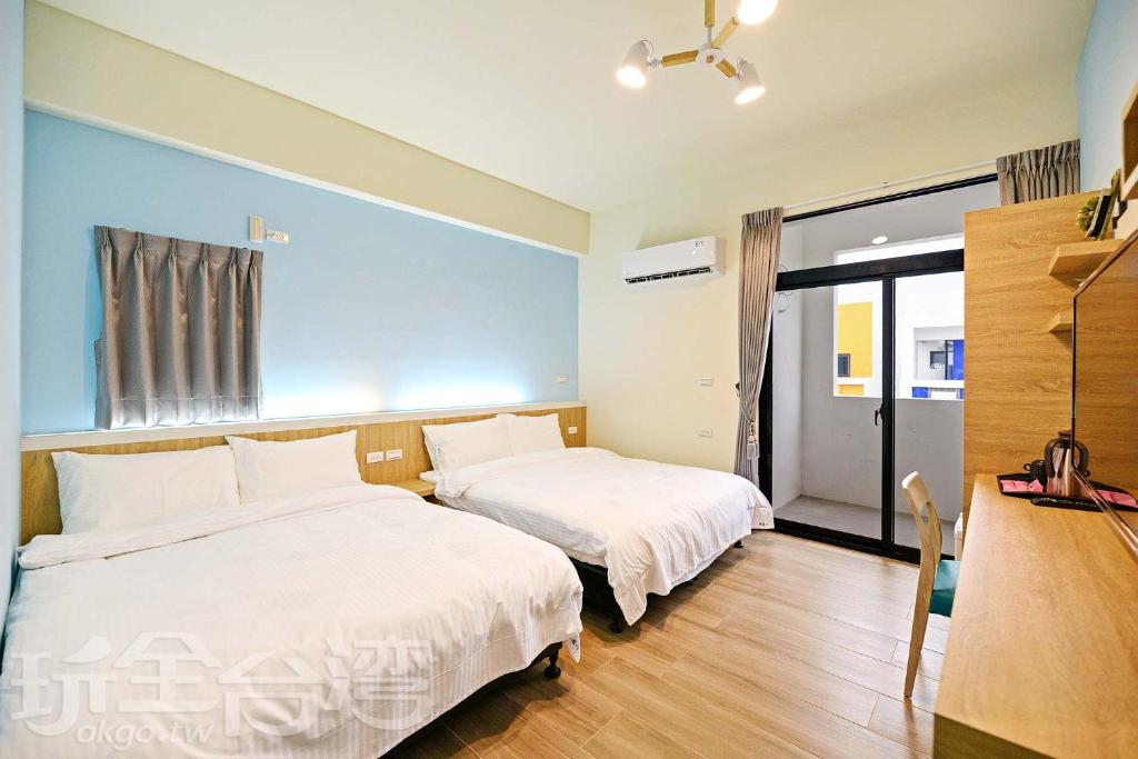 Penghu Yuanmuxin Homestay في ماغونغ: غرفة نوم بسريرين ومكتب ونافذة