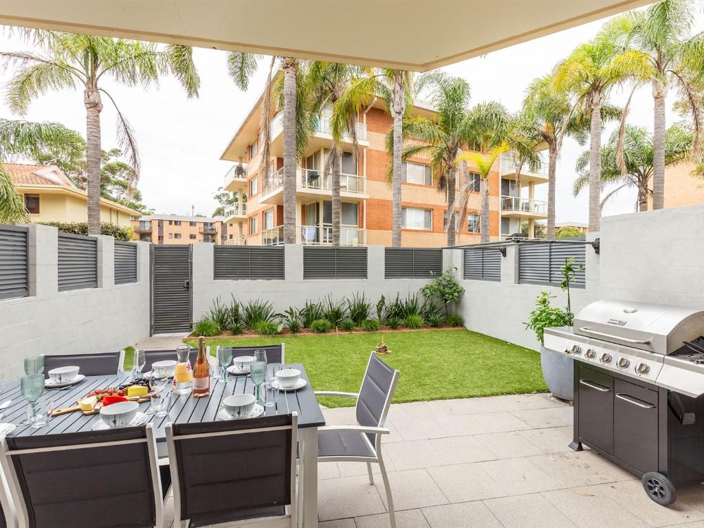 an outdoor patio with a table and a grill at Kristie Court 3 7 Weatherly Close with air con and close to the beach in Nelson Bay
