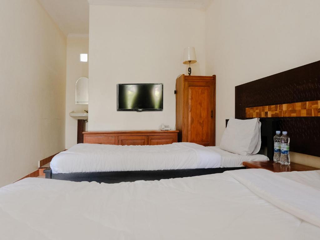 Postel nebo postele na pokoji v ubytování Hotel Mahkota Plengkung by ecommerceloka