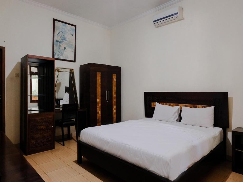 Postel nebo postele na pokoji v ubytování Hotel Mahkota Plengkung by ecommerceloka