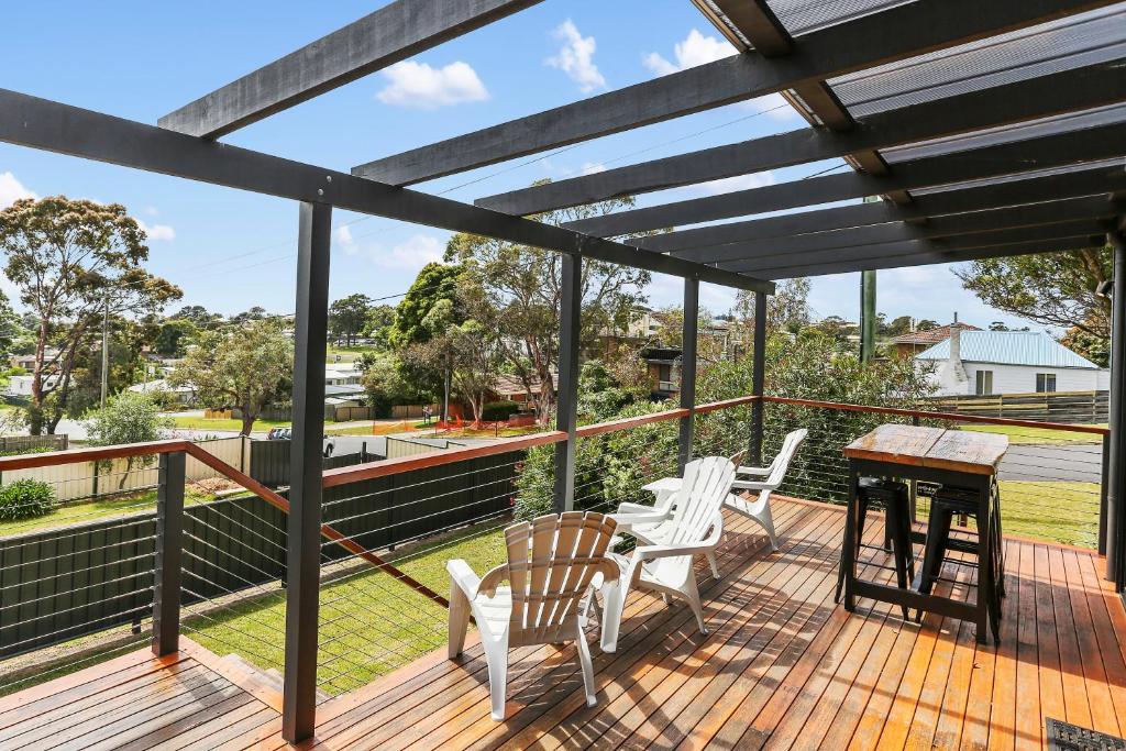 a deck with two chairs and a table on it at Avalon House in Eden