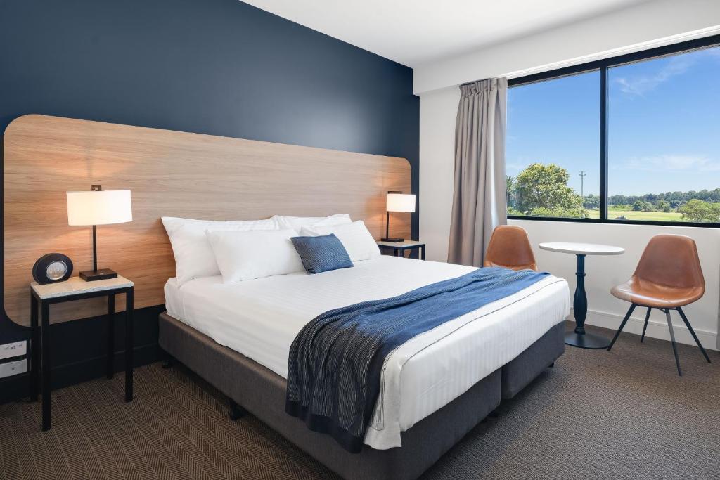 a hotel room with a bed and a large window at Springs Newcastle in Newcastle