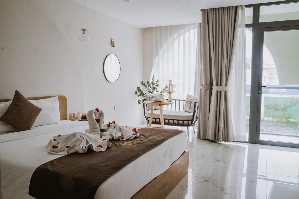 a bedroom with a bed and a table and a window at Maple Suite Hotel & Apartment in Danang