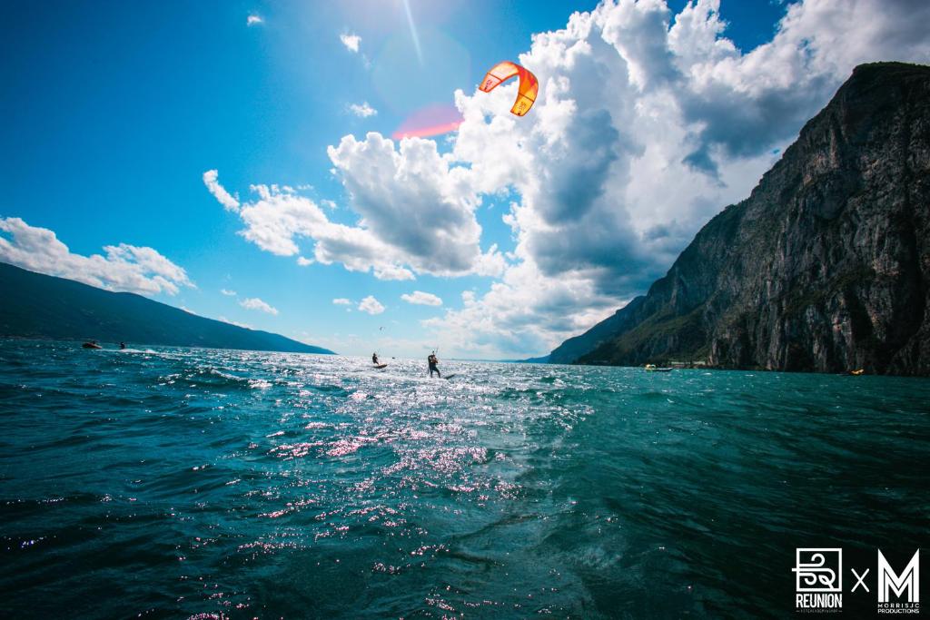 "La Locanda" Campione del Garda في كامبيوني ديل غاردا: شخص طائرة ورقية تتصفح المياه على البحيرة