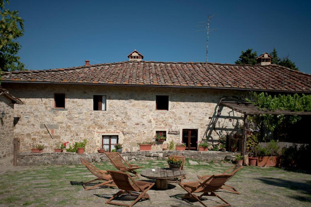 a stone house with chairs and a table in front of it at Agriturismo La Pieve in Pelago