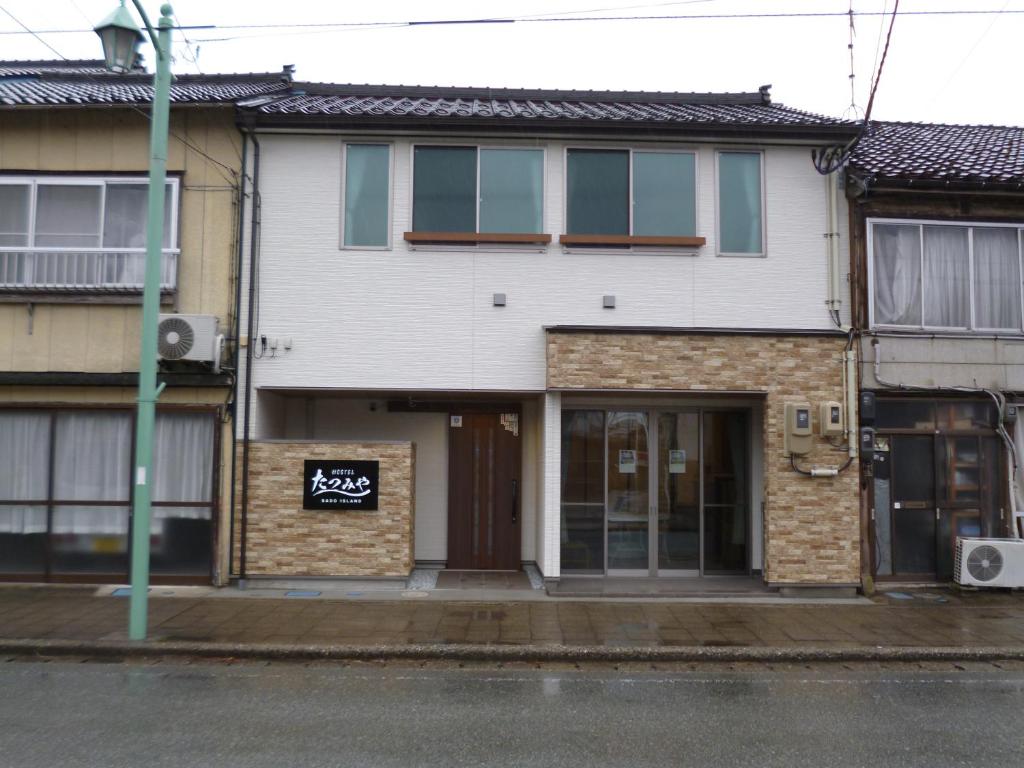 a building on the side of a street at ホステルたつみや in Sado